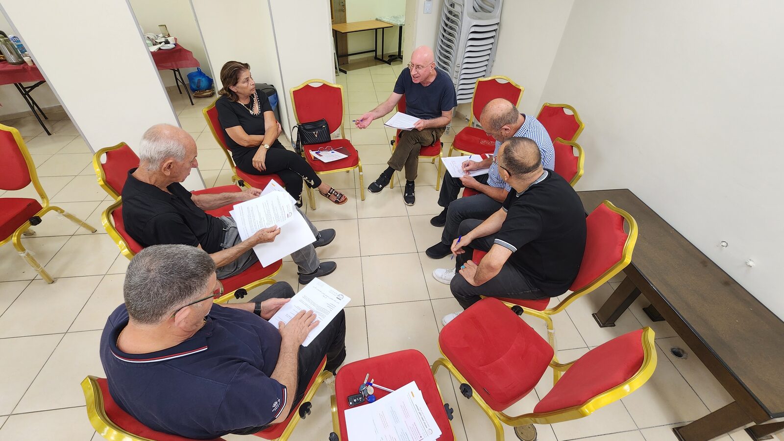 A small committee group reviews printed sheets together.