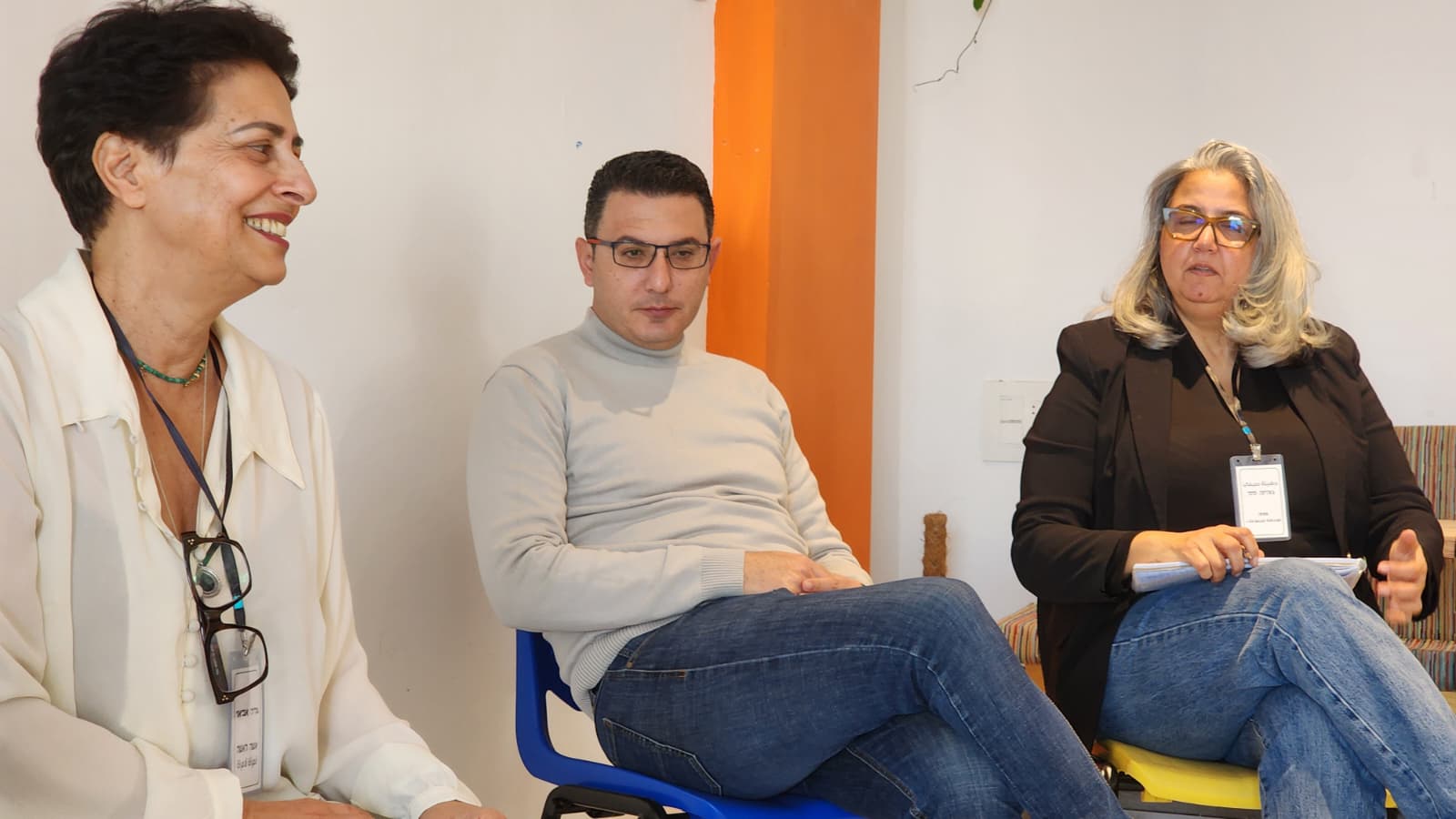 مشاركٌ يضحك بين اثنين آخرين خلال جلسة العمل.